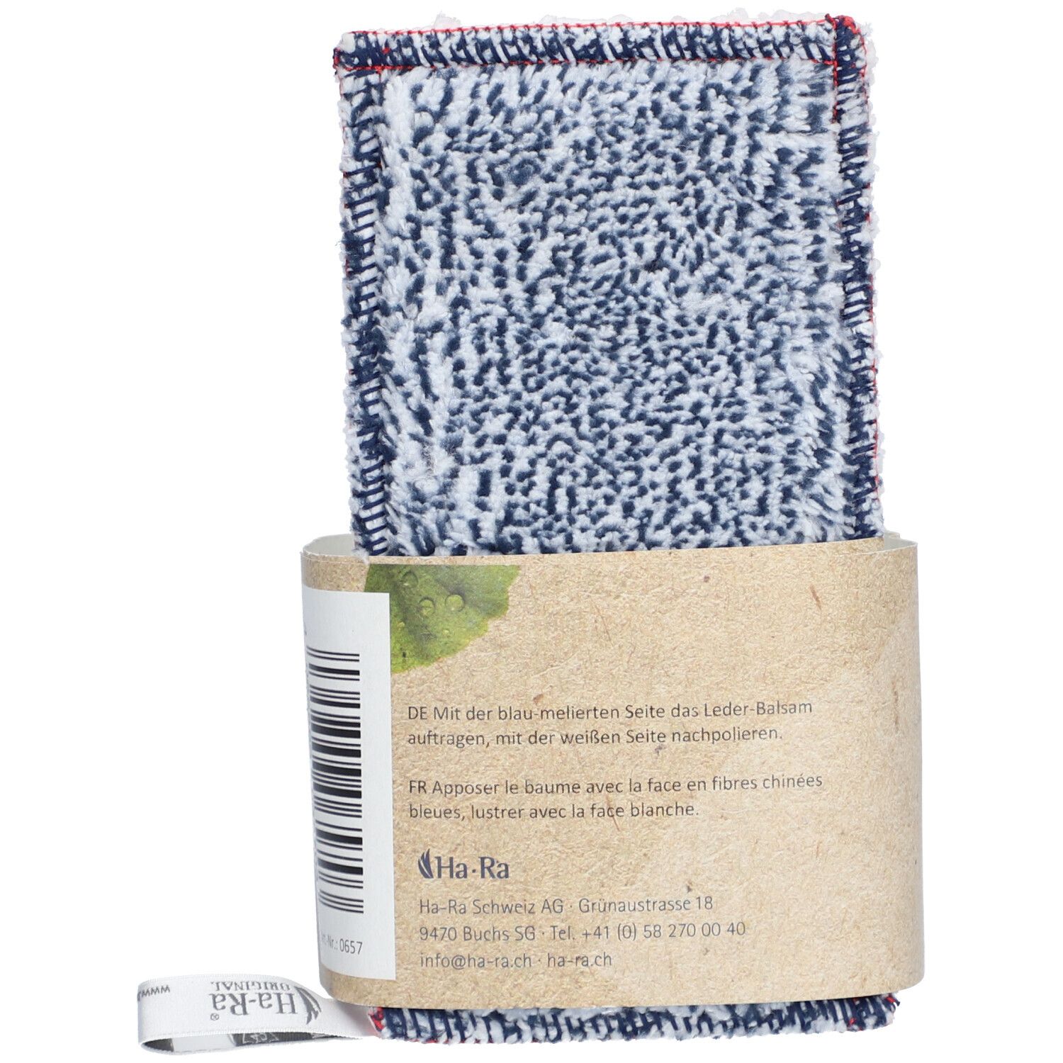 Verzorgingsdoek met lederbalsemverpakking. Doek met blauw-wit patroon en rode rand. Verpakking van bruin papier. Tekst op de verpakking.