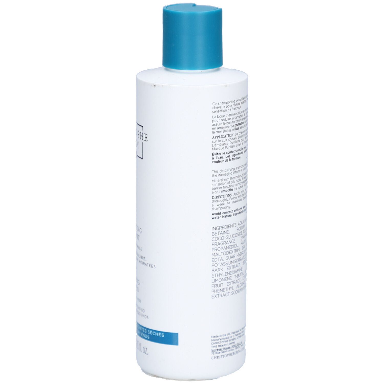 Achterkant van de witte fles met blauwe dop. Meertalige tekst. Ingrediënten en instructies.