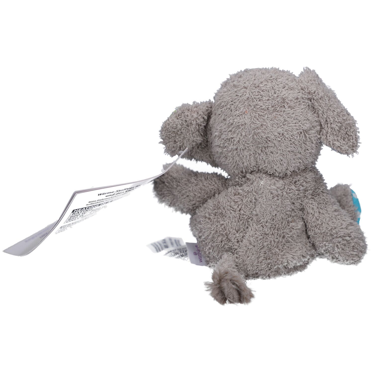 Achteraanzicht van een grijze stoffen olifant met label. Kleine staartpunt zichtbaar.