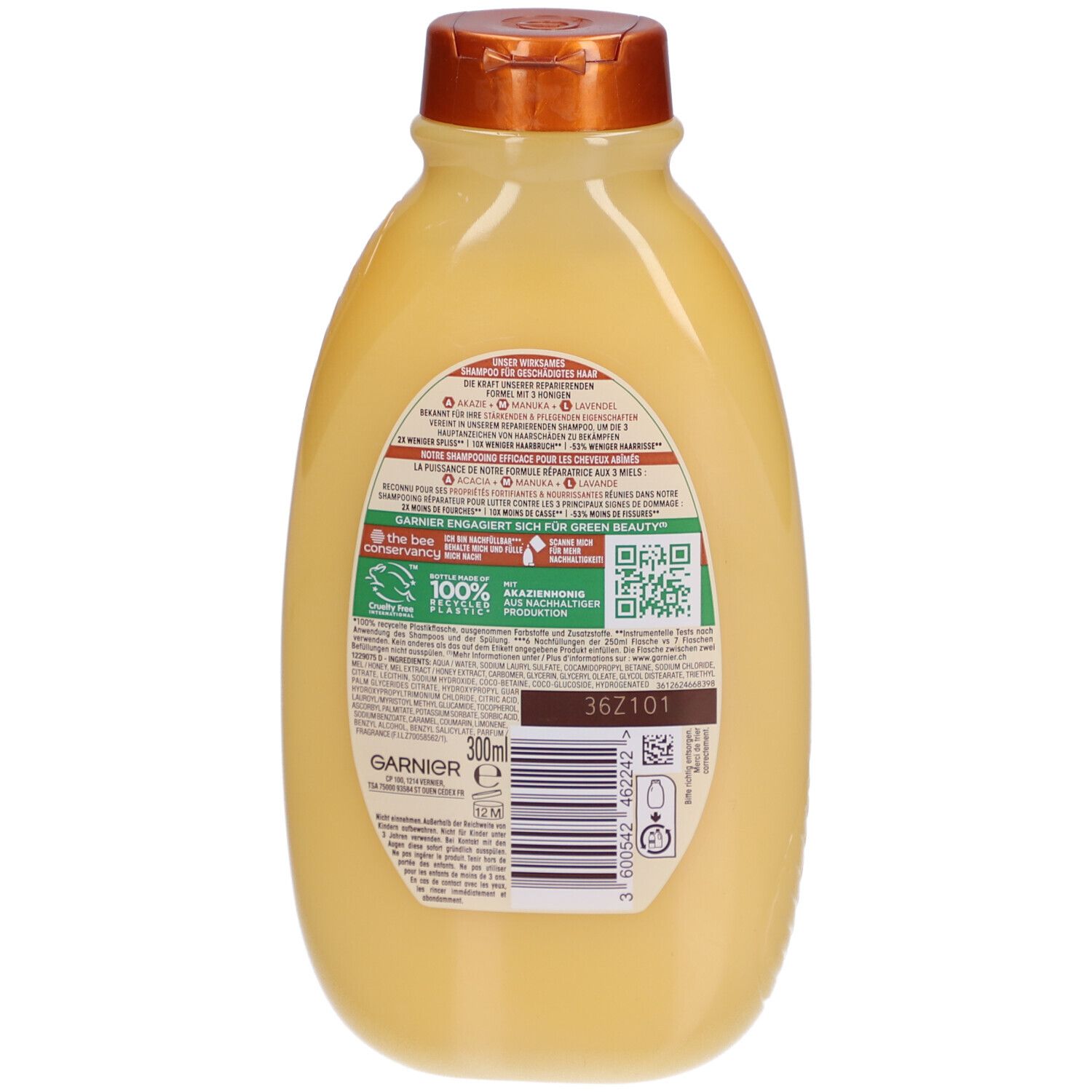 Achterkant van de Garnier Ultra Doux shampoo fles. Gele fles met bruine dop. Tekst en QR-code op het etiket.