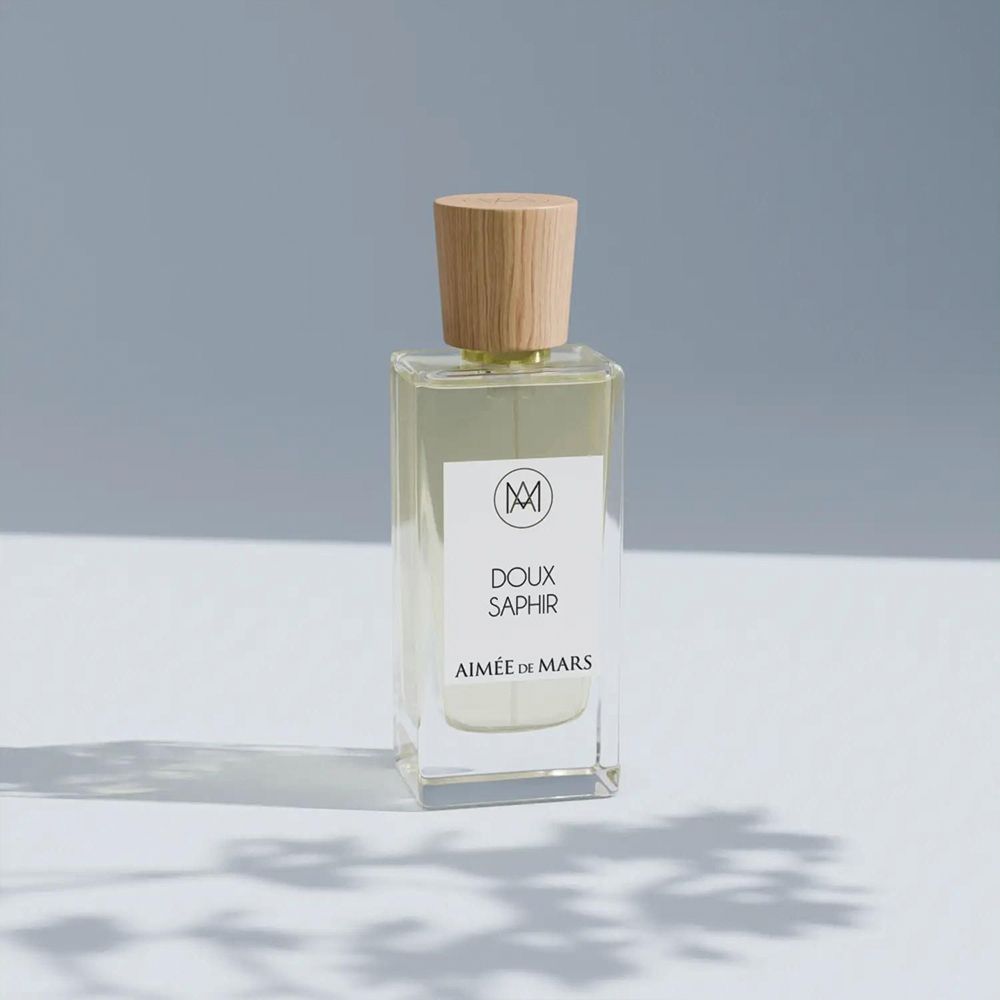 Flacon de parfum avec bouchon en bois. Étiquette: "Doux Saphir" et "Aimée de Mars".