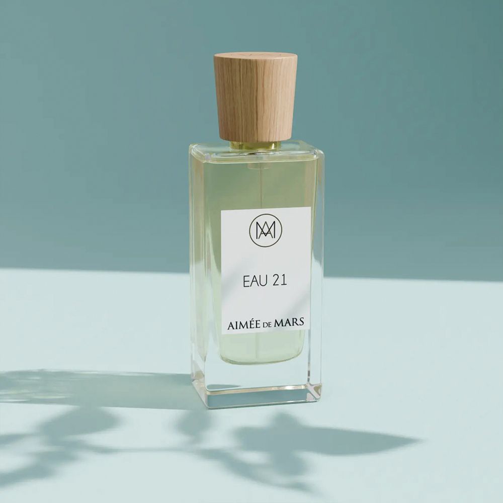 Aimée de Mars Eau 21 Eau de Parfum. Flacon en verre avec bouchon en bois. Étiquette blanche avec logo et nom du produit.
