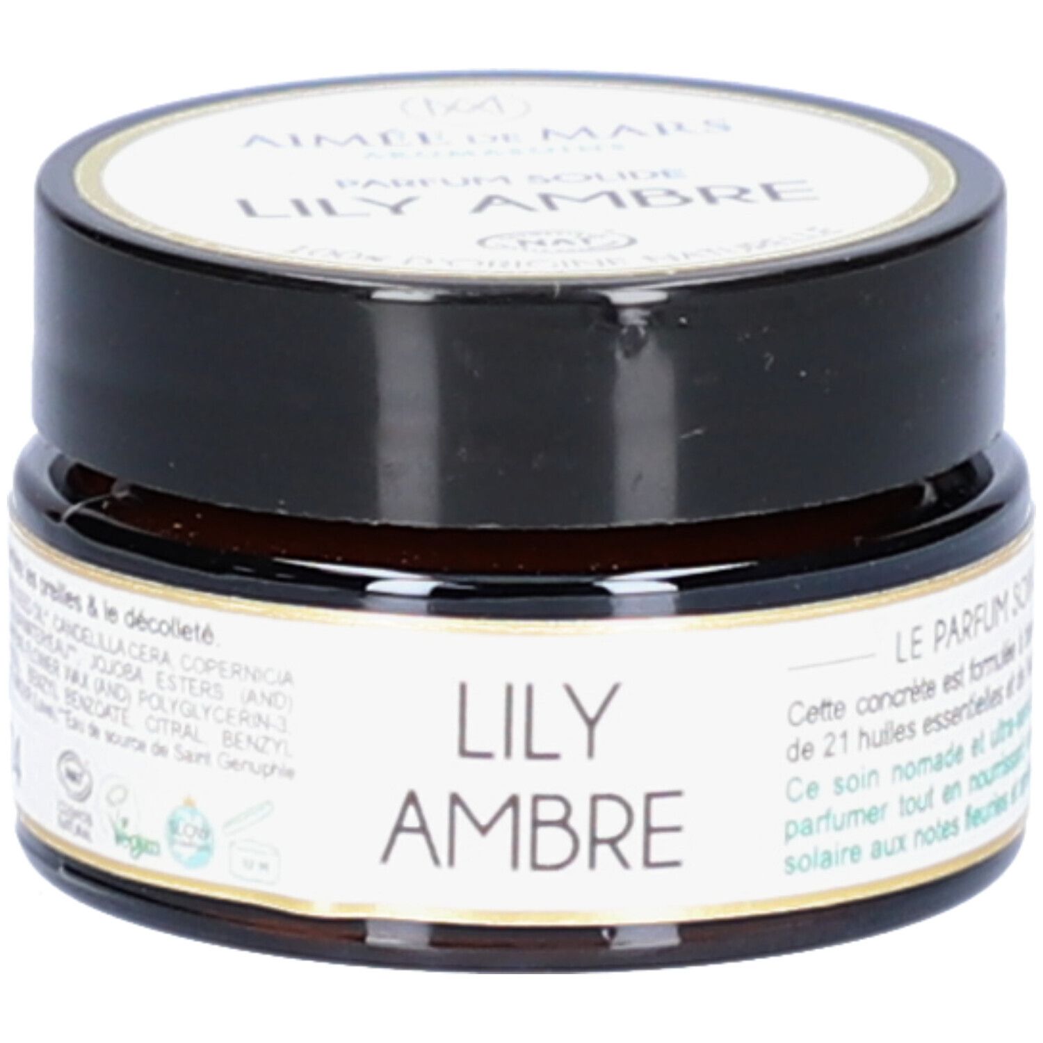 Bruine pot met zwarte deksel. Etiket met productnaam en merk. Opschrift: Lily Ambre Parfum Solide.