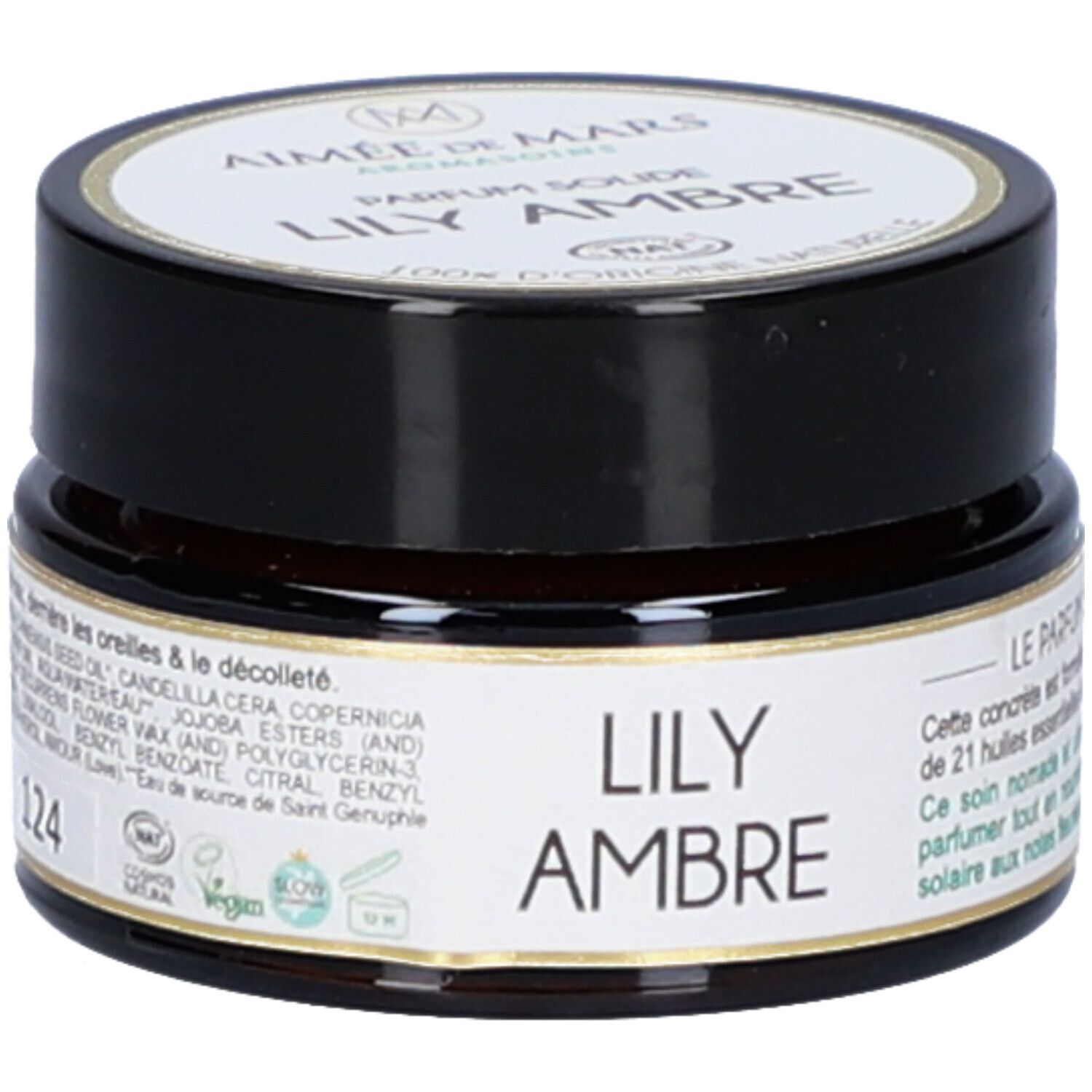 Bruine pot met zwarte deksel. Etiket met productnaam en merk. Opschrift: Lily Ambre Parfum Solide. 124.