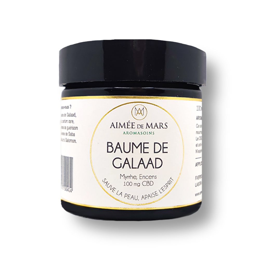 Pot met zwarte deksel. Witte en gouden etiket: AIMÉE DE MARS, Baume de Galaad, Myrrhe, Encens, 100 mg CBD. Witte achtergrond.