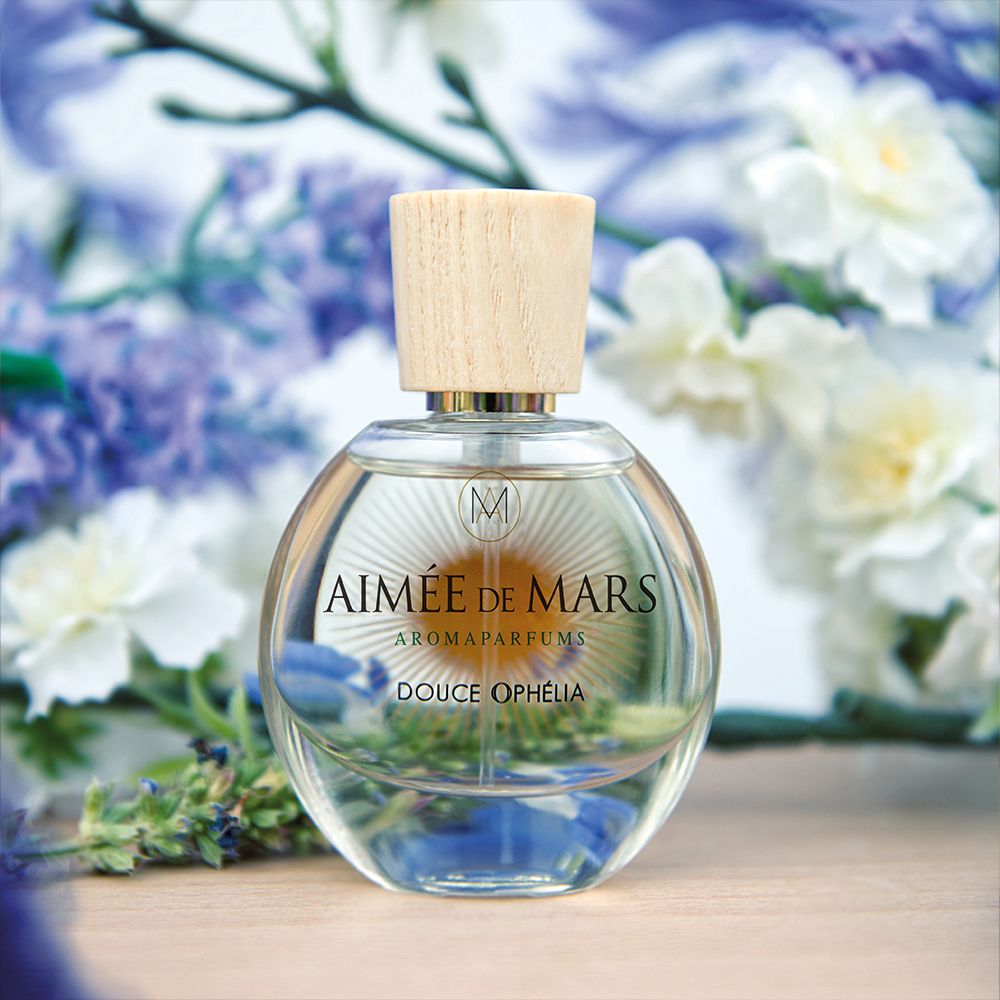 Flacon en verre avec bouchon en bois. Inscription : Aimée de Mars, Douce Ophélia. Fond : fleurs et bois.