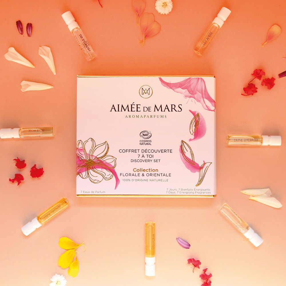 Aimée de Mars® Discovery Set Collection Florale. Une boîte et sept petits flacons sur fond rose. Pétales.