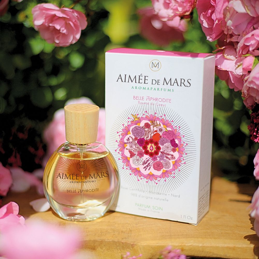 Flacon de parfum et emballage. Inscription : Aimée de Mars, Belle Aphrodite. Motif floral. Roses en arrière-plan.