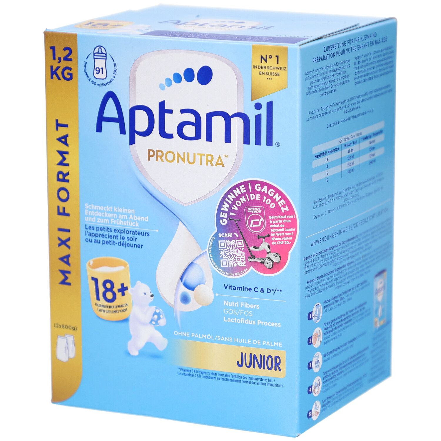 Blauw-witte kartonnen verpakking. Bevat Aptamil Pronutra Juniormilch 18+. Maxi Formaat 1,2 kg. Met illustraties en tekst.