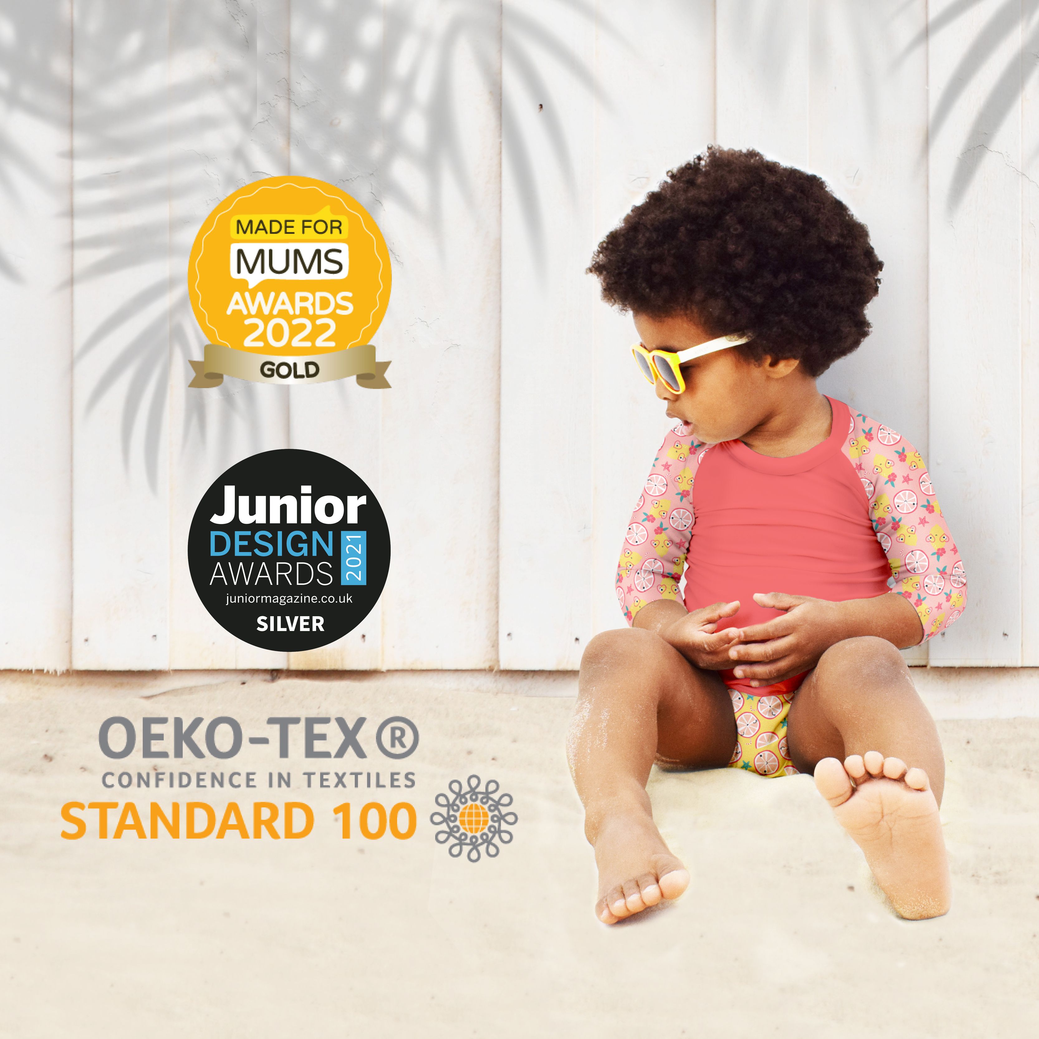 Enfant en maillot de bain. Prix d'or : MADE FOR MUMS AWARDS 2022 GOLD, JUNIOR DESIGN AWARDS 2021 SILVER. Texte : OEKO-TEX STANDARD 100.