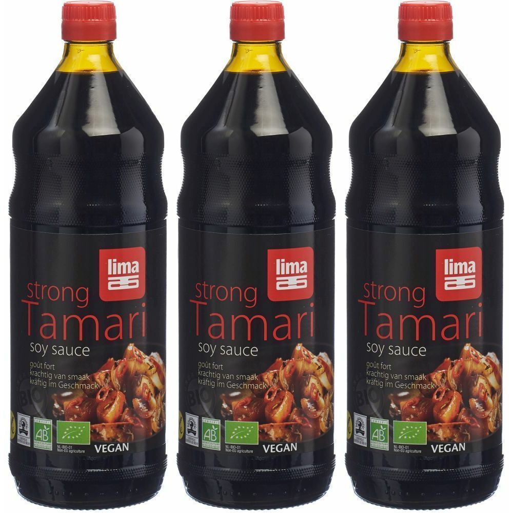 Trois bouteilles de sauce soja avec bouchon rouge. Étiquettes noires avec texte "strong Tamari soy sauce". Label végan.