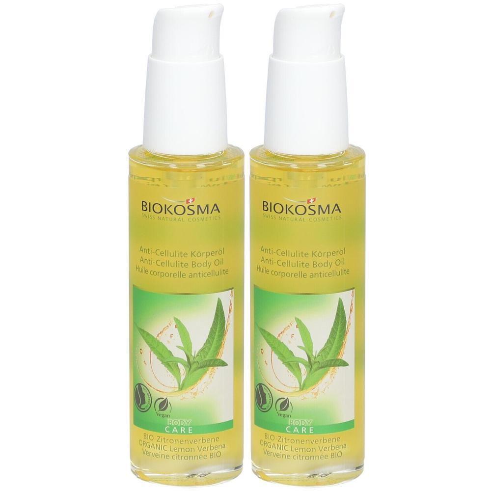Deux flacons d'huile corporelle anti-cellulite Biokosma. Liquide jaune, pompes blanches, étiquettes vertes avec motif végétal et texte.