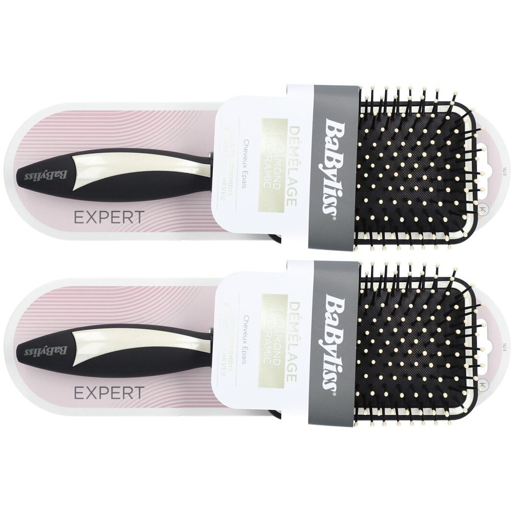 Twee BaByliss haarborstels. Zwarte handgreep met zilveren inzet, rechthoekige borstelkop met zwarte pinnen. Verpakking met productnaam.