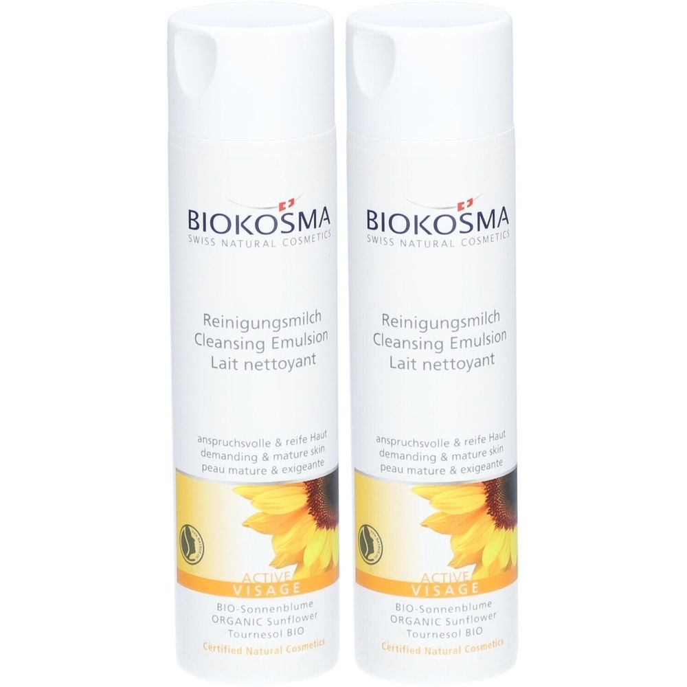 Twee flessen Biokosma reinigingsmelk. Witte flessen met geel etiket en zonnebloemmotief. Tekst: Reinigungsmilch, Cleansing Emulsion.