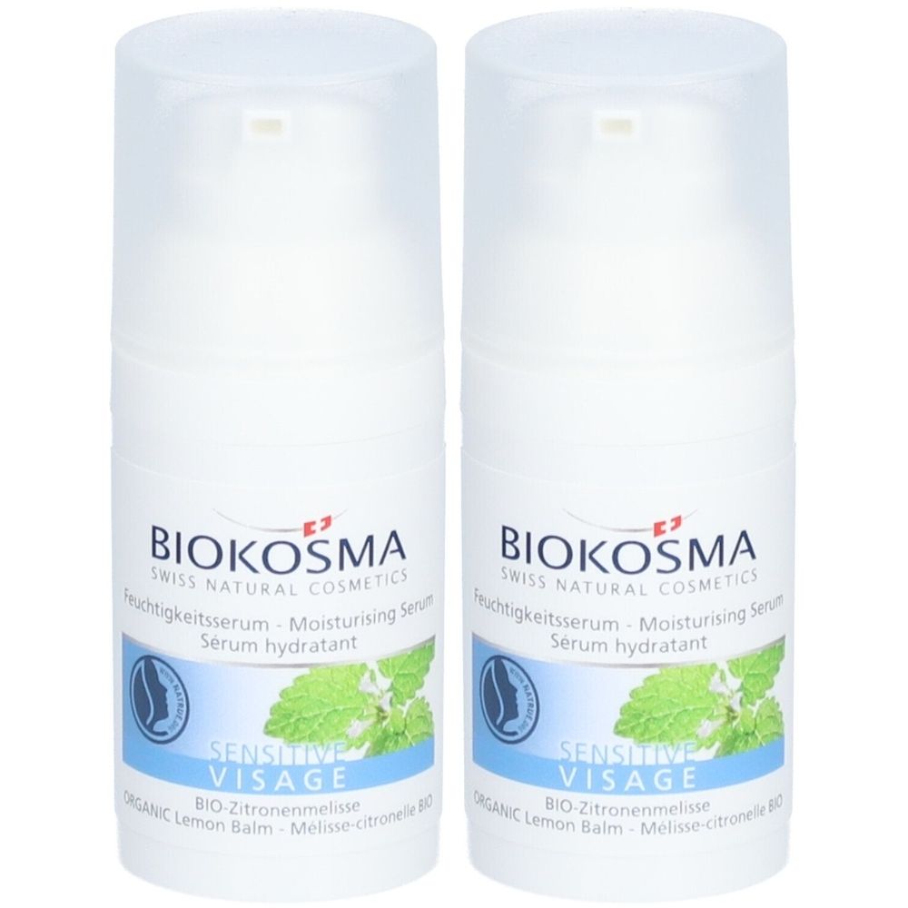 Twee witte dispenserflessen. Opschrift: Biokosma, Moisturising Serum, Sensitive Visage. Afbeelding van citroenmelisse.