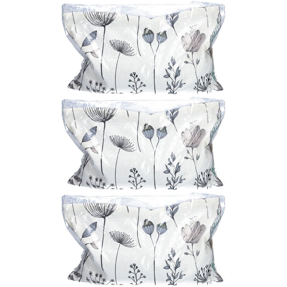 Trois coussins floraux emballés dans du plastique. Le motif présente des fleurs et des feuilles grises sur fond blanc.