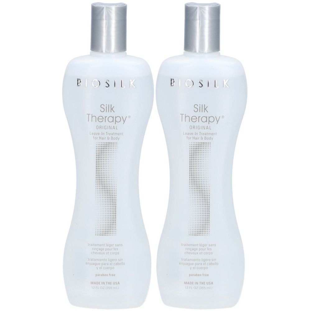 Twee flessen BioSilk Silk Therapy Original. Witte flessen met zilveren doppen. Tekst: Leave-in Treatment voor haar & lichaam.
