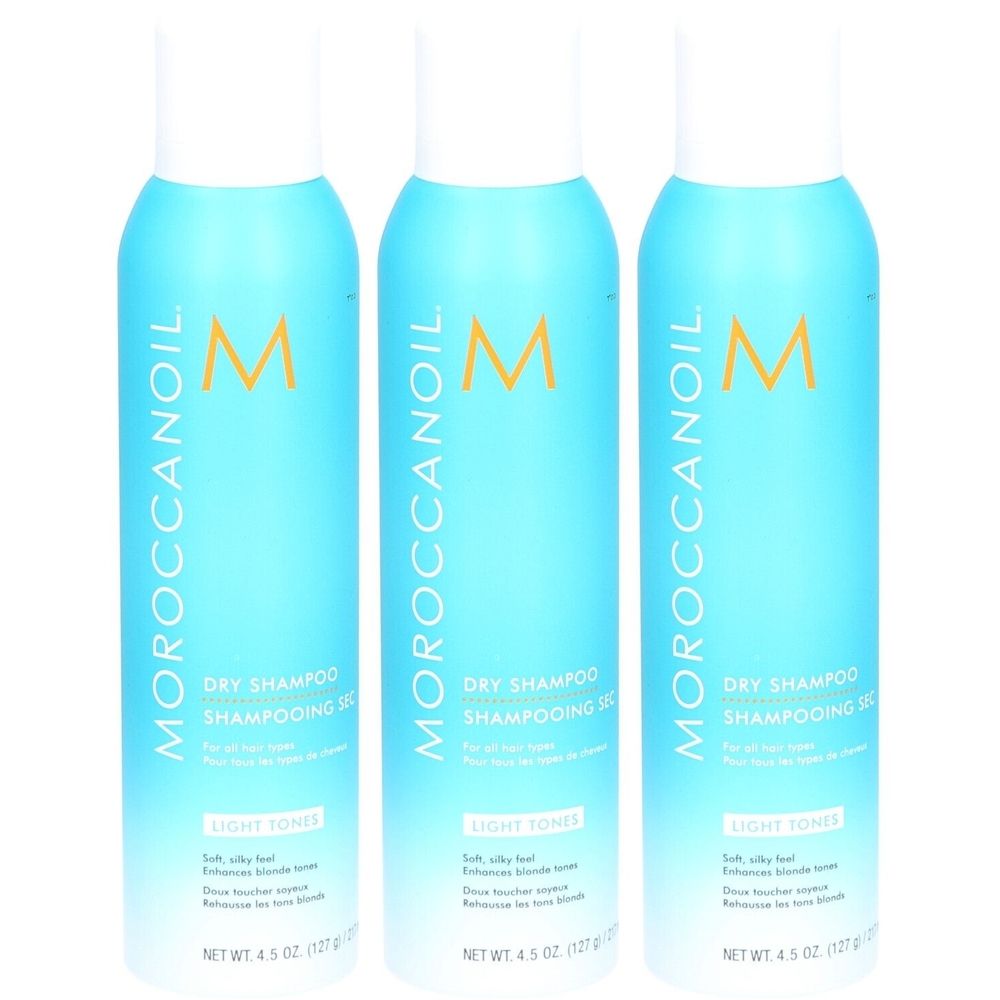 Drie blauwe spuitbussen met witte dop. Opschrift: Moroccanoil, Dry Shampoo, Light Tones. Nettogewicht 4,5 oz (127 g).
