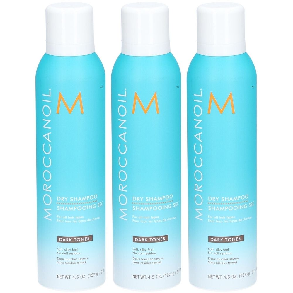 Drie blauwe spuitbussen met witte dop. Opschrift: Moroccanoil Dry Shampoo, Dark Tones. Netto gewicht: 4,5 oz (127 g).