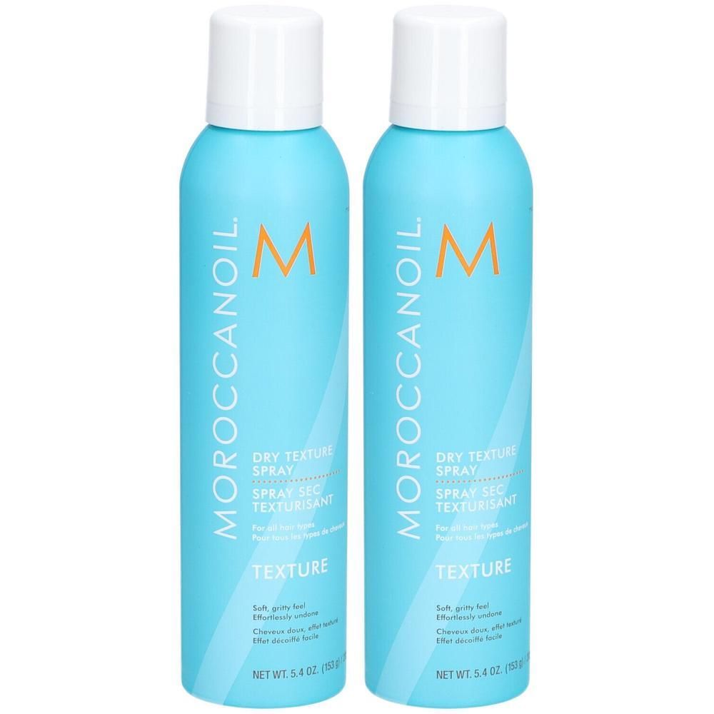 Twee lichtblauwe spuitbussen met witte dop, Moroccanoil Dry Texture Spray.