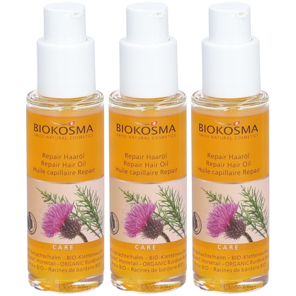 Drie flessen haarolie met witte doppen. Opschrift: BIOKOSMA, Repair Hair Oil. Afbeelding van een paarse bloem.