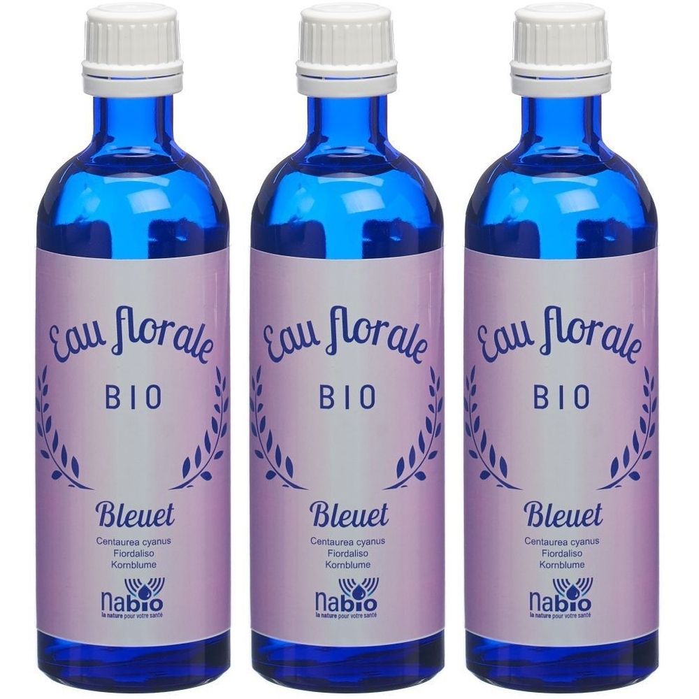 Trois flacons en verre bleu avec bouchons blancs. Étiquettes avec "Eau florale BIO Bleuet" et "nabio".