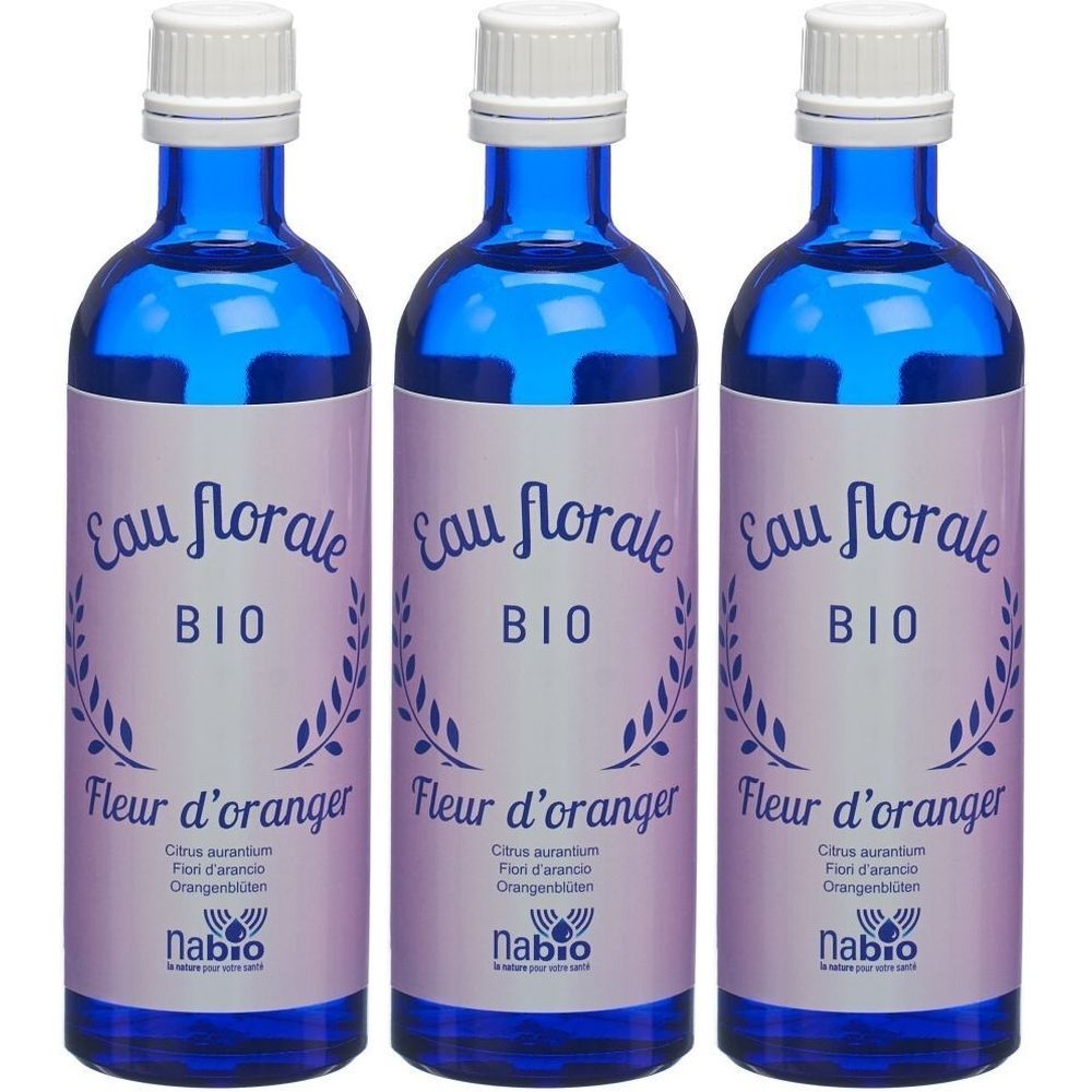 Trois flacons en verre bleu avec bouchon blanc. Étiquette "Eau florale BIO Fleur d'oranger". Marque Nabio.