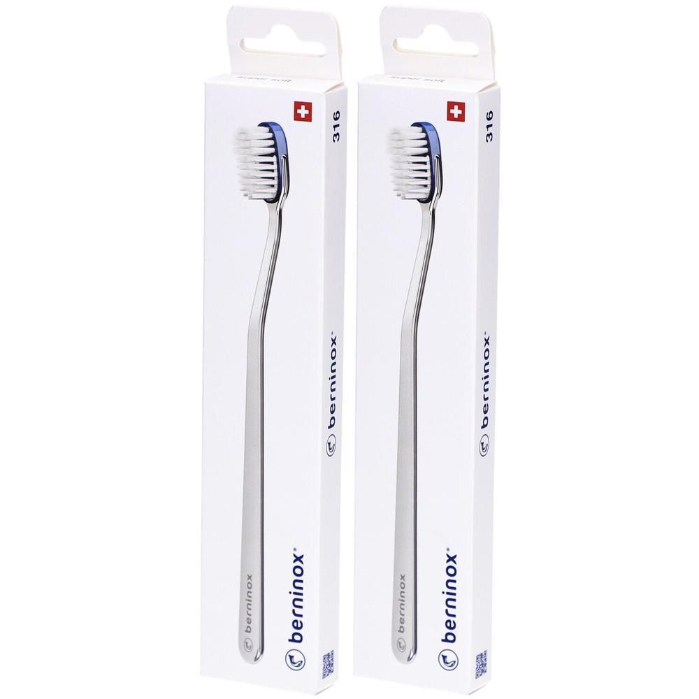 Deux brosses à dents dans des emballages blancs. Têtes de brosse avec poils bleus et manches argentés visibles. Emballage avec croix suisse.