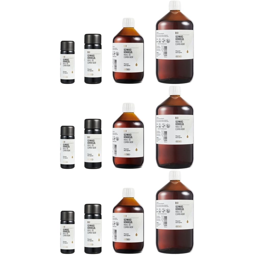 Verschillende flessen en kleine flesjes. Bruine vloeistof in glazen flessen met witte etiketten. Zwarte doppen op kleine flesjes.