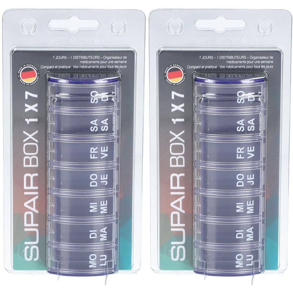 Twee verpakkingen SUPAIR BOX 1x7, wekelijkse pillendoosjes. Blauwe, cilindrische containers met zeven compartimenten, gelabeld met dagen.