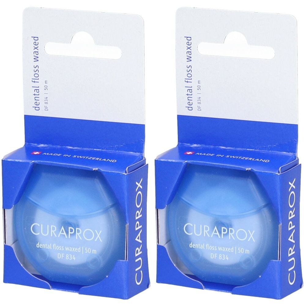 Twee verpakkingen tandzijde in blauwe verpakking. Opschrift: CURAPROX, dental floss waxed, DF 834, 50m. Verpakking met ophanghaak.
