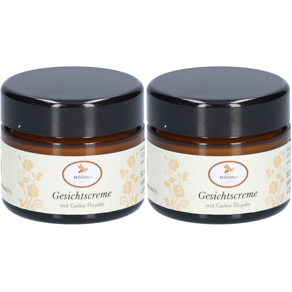 Deux pots de crème visage Röösli avec couvercles noirs. Inscription: Crème visage avec Gelée Royale. Étiquette à motifs floraux.
