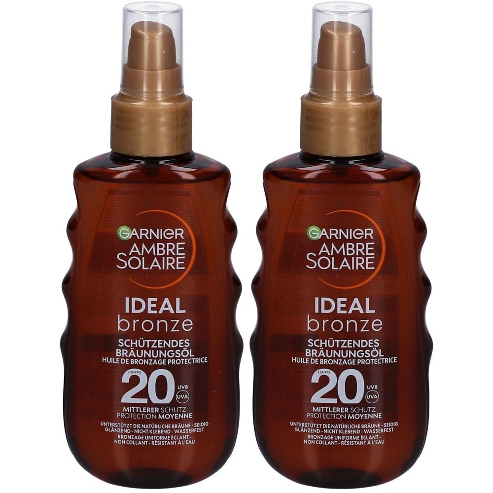 Twee flessen Garnier Ambre Solaire. Bruine vloeistof in bruine flessen met verstuiver. Opschrift: Ideal Bronze, SPF 20.