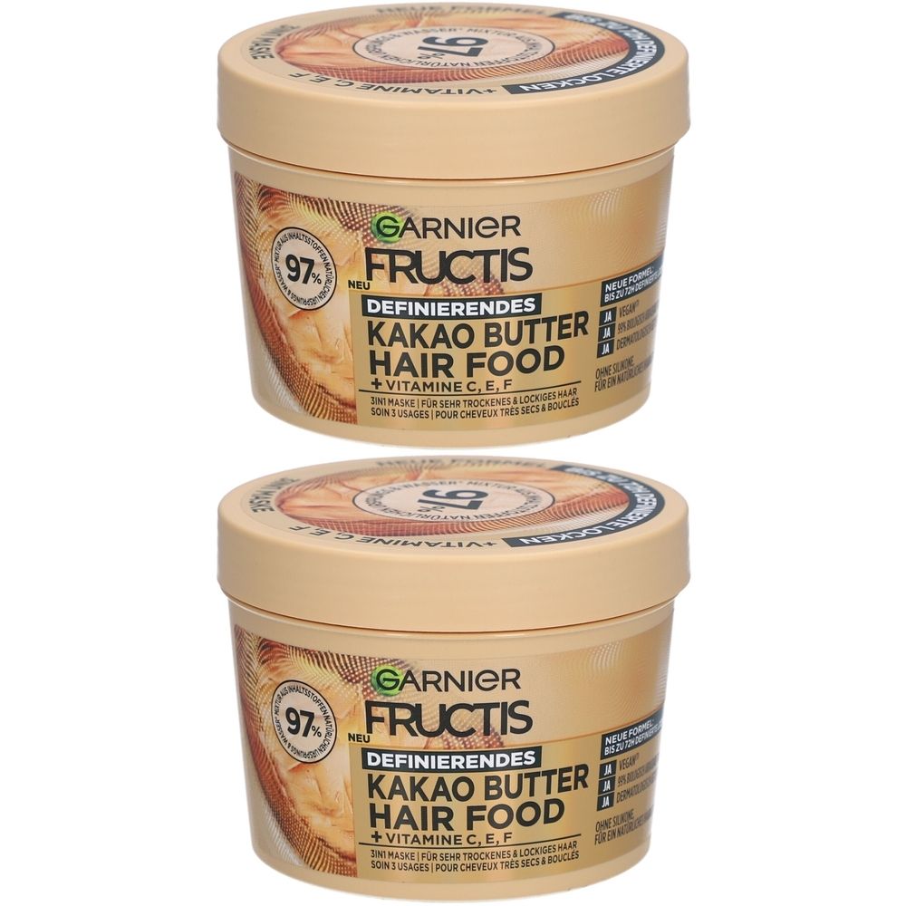 Twee crèmekleurige potten. Opschrift: Garnier Fructis Kakao Butter Hair Food. Met 97% natuurlijke ingrediënten en vitaminen.