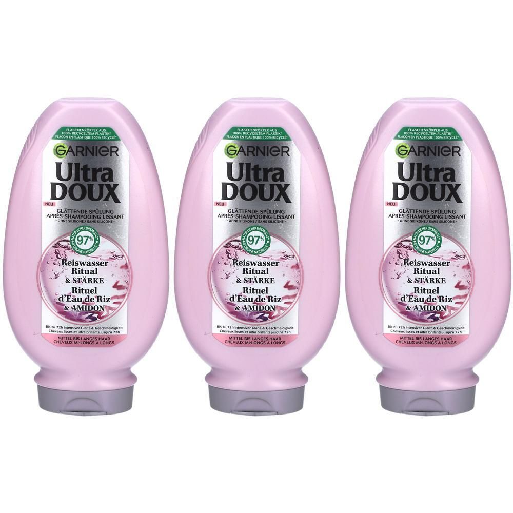 Trois flacons roses de revitalisant GARNIER Ultra Doux. Inscription: Rituel Eau de Riz & Amidon. 97% d'ingrédients naturels.