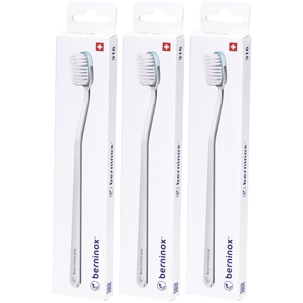 Trois brosses à dents dans des emballages blancs. Les brosses ont un manche argenté et une tête de brosse bleu clair. Le nom "berninox" est visible.