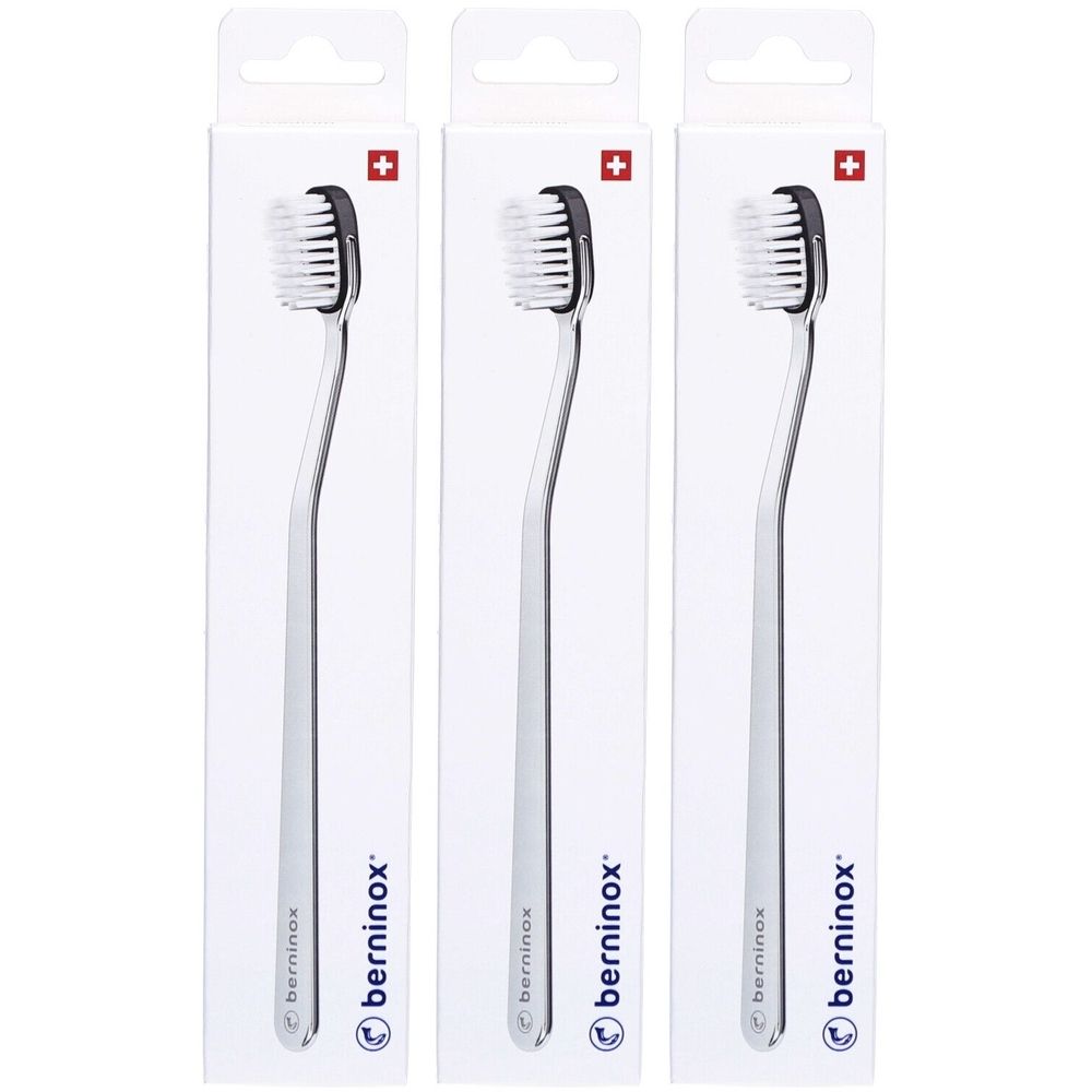 Trois brosses à dents emballées. Soies noires, manche argenté. Croix suisse en haut. Marque : berninox.