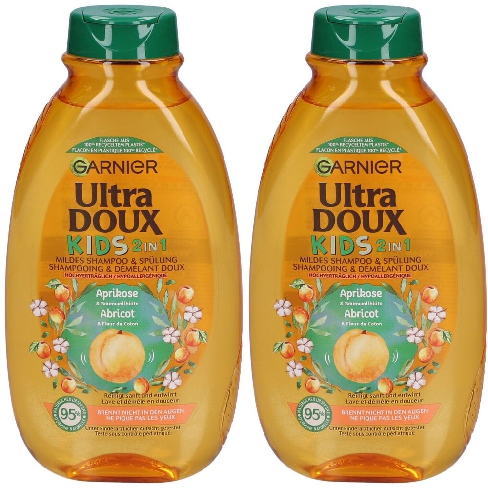 Twee flessen shampoo. Opschrift: GARNIER Ultra DOUX KIDS 2in1. Met abrikoos en katoenbloem. Groene dop, oranje vloeistof.