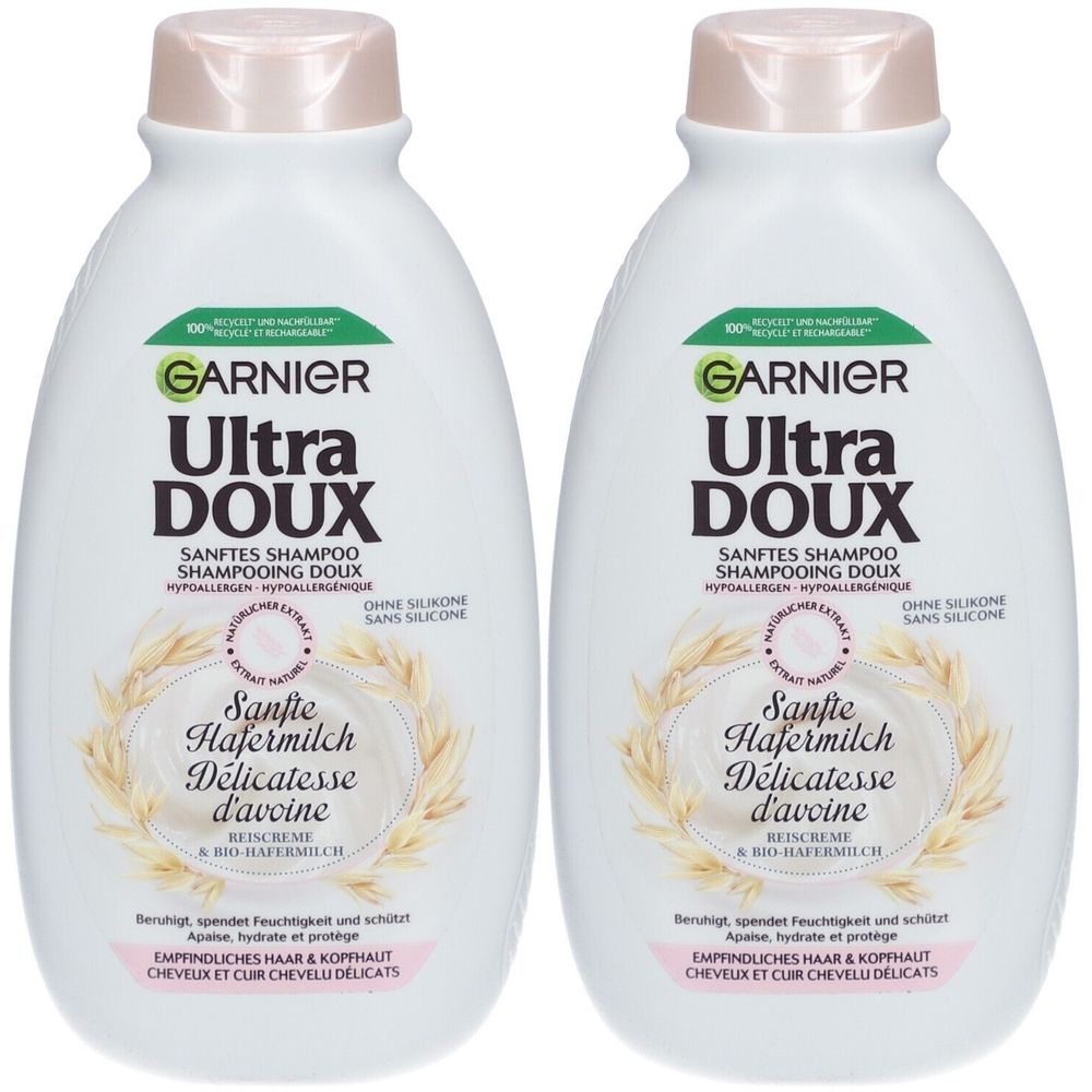 Deux flacons de shampooing blancs. Inscription: GARNIER Ultra DOUX. Texte: Sanfte Hafermilch Délicatesse d'avoine. Sans silicone. Pour cheveux délicats.
