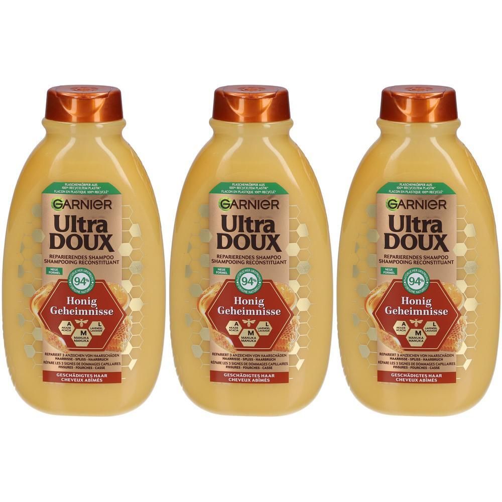 Drie flessen shampoo. Op elke fles staat: GARNIER Ultra DOUX, Honig Geheimnisse. Gele flessen met bruine doppen.