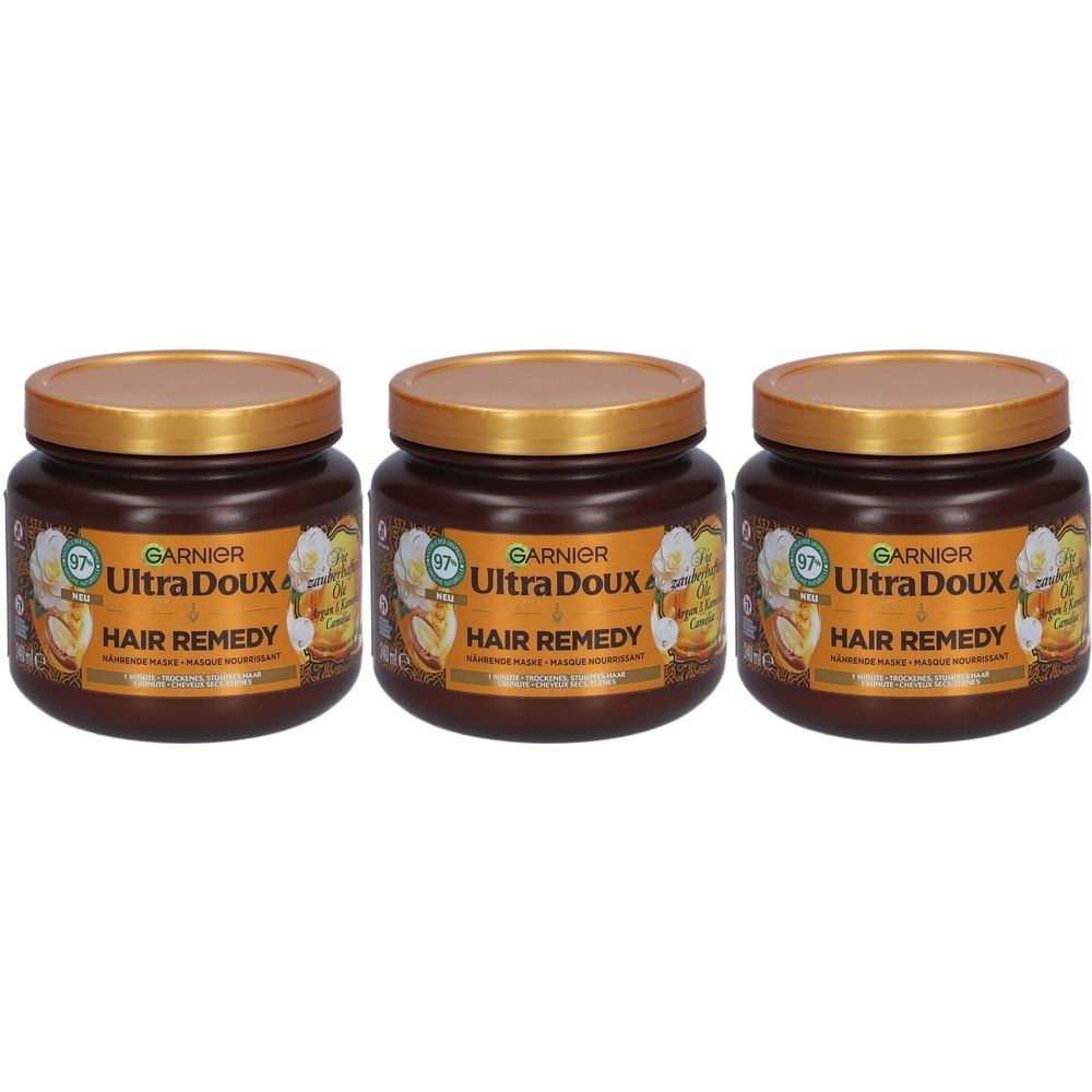 Drie bruine Garnier Ultra Doux haarmaskerpotten met gouden deksels. Het etiket vermeldt "Hair Remedy" en "Argan & Camelia Olie".