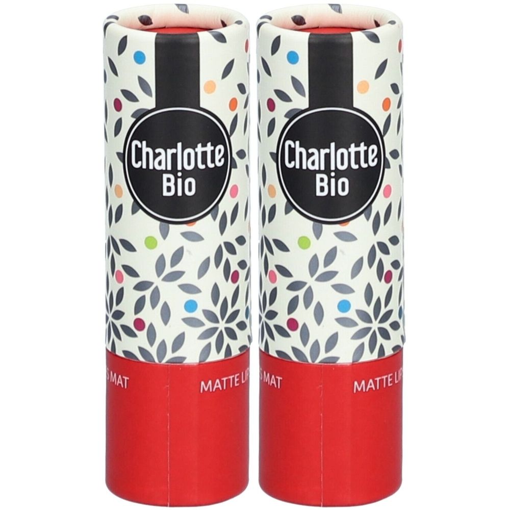 Twee lippenstiften in cilindrische verpakkingen. Opschrift Charlotte Bio. Rode onderkant, bloemenachtergrond.