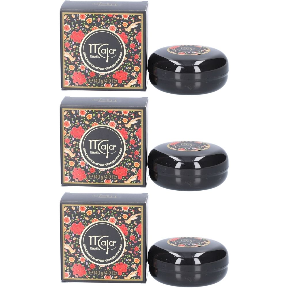 Trois boîtes et boîtes de savon noires. "Maja" avec un motif floral est sur les boîtes. "Maja" est également visible sur les boîtes.
