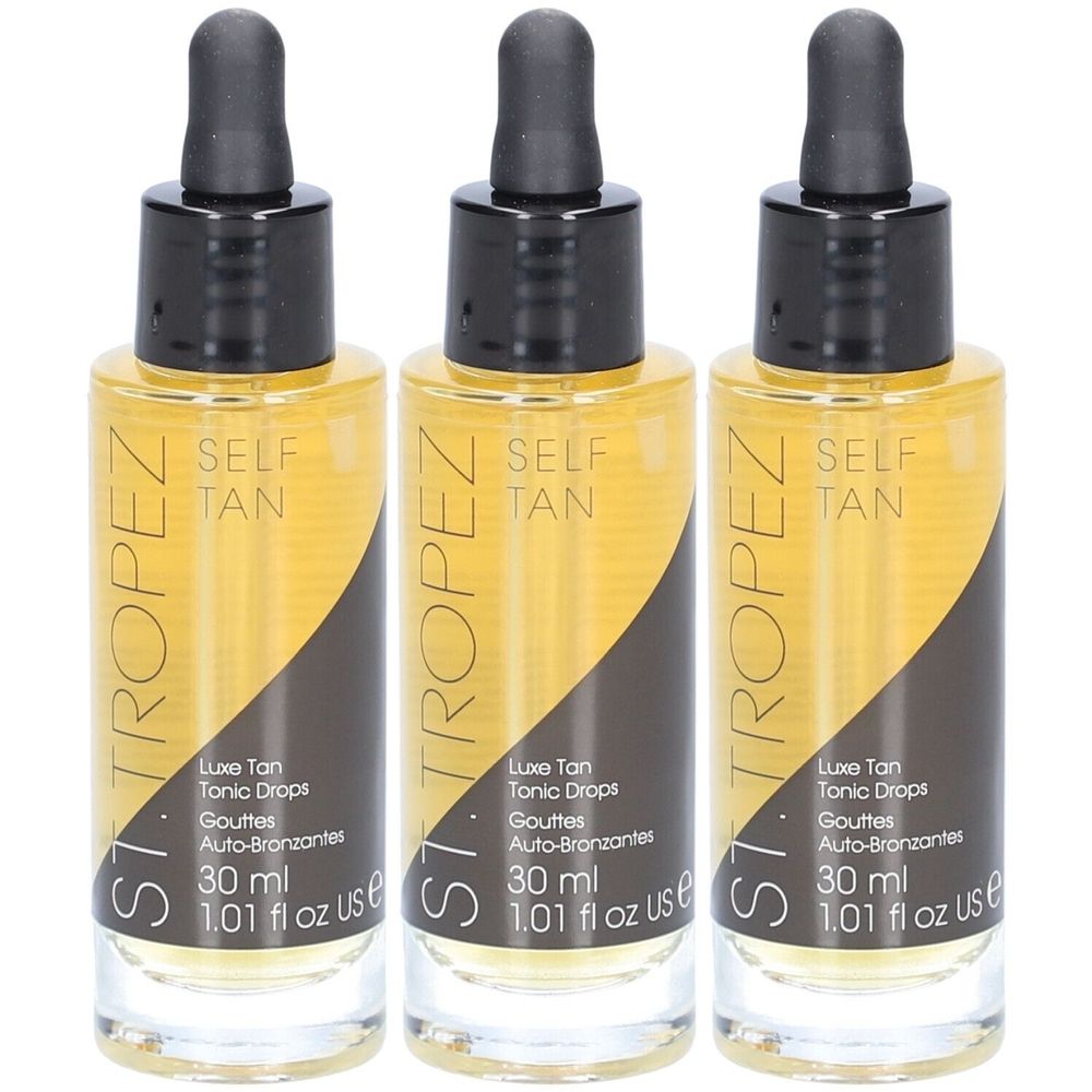 Drie flessen bruine vloeistof. Zwarte doppen met druppelaars. Opschrift: ST. TROPEZ, SELF TAN, Luxe Tan Tonic Drops, 30 ml, 1.01 fl oz US.