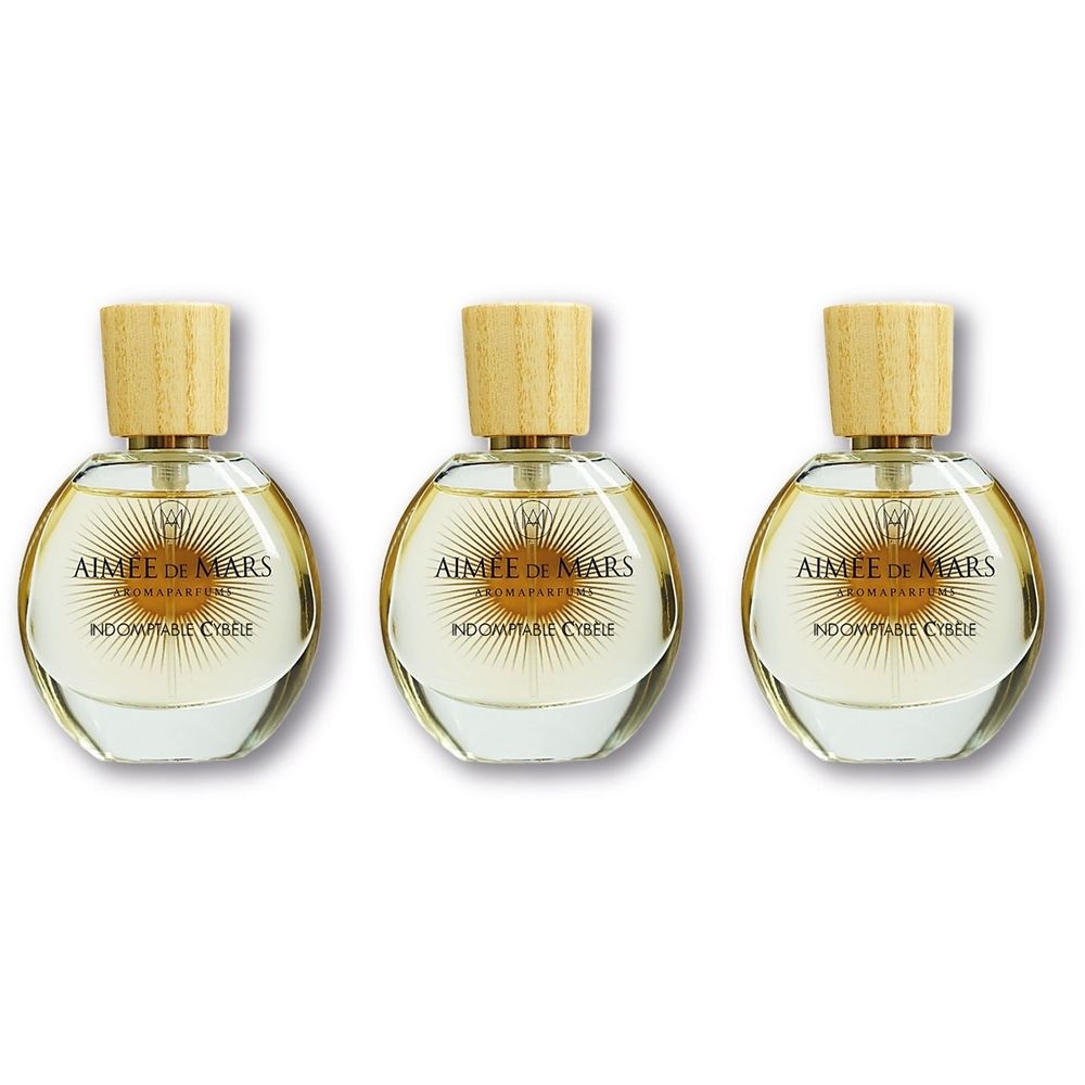 Trois flacons ronds en verre avec bouchon en bois, remplis de parfum clair.