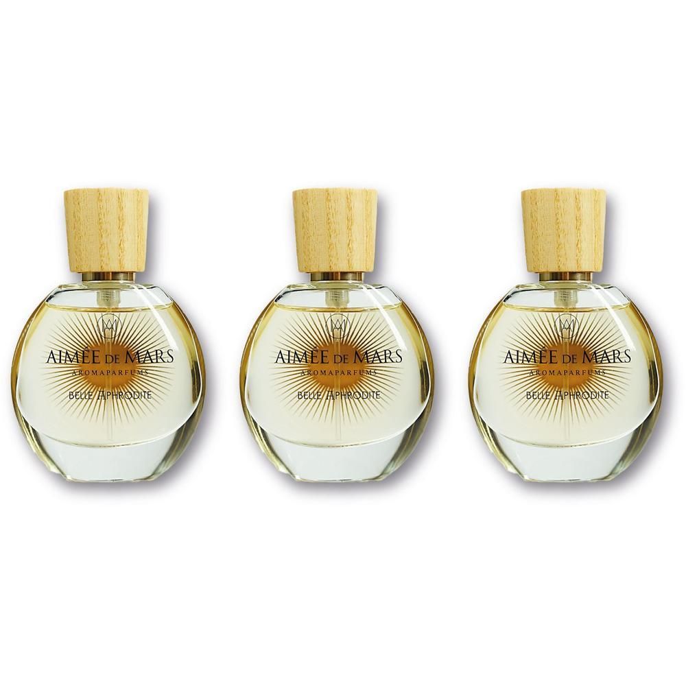 Trois flacons ronds en verre avec bouchon en bois, remplis de parfum clair.