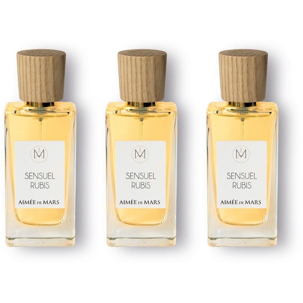 Drie glazen flacons met eau de parfum, elk met een houten dop en etiket.