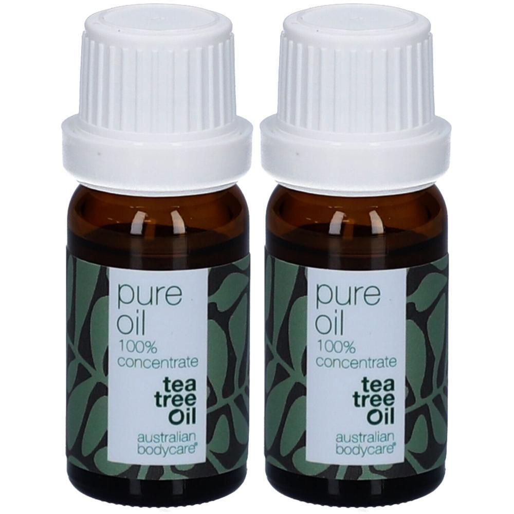 Deux flacons d'huile d'arbre à thé. Flacons en verre brun avec bouchons blancs et étiquettes. Inscription : pure oil, 100% concentrate, tea tree oil, Australian Bodycare.