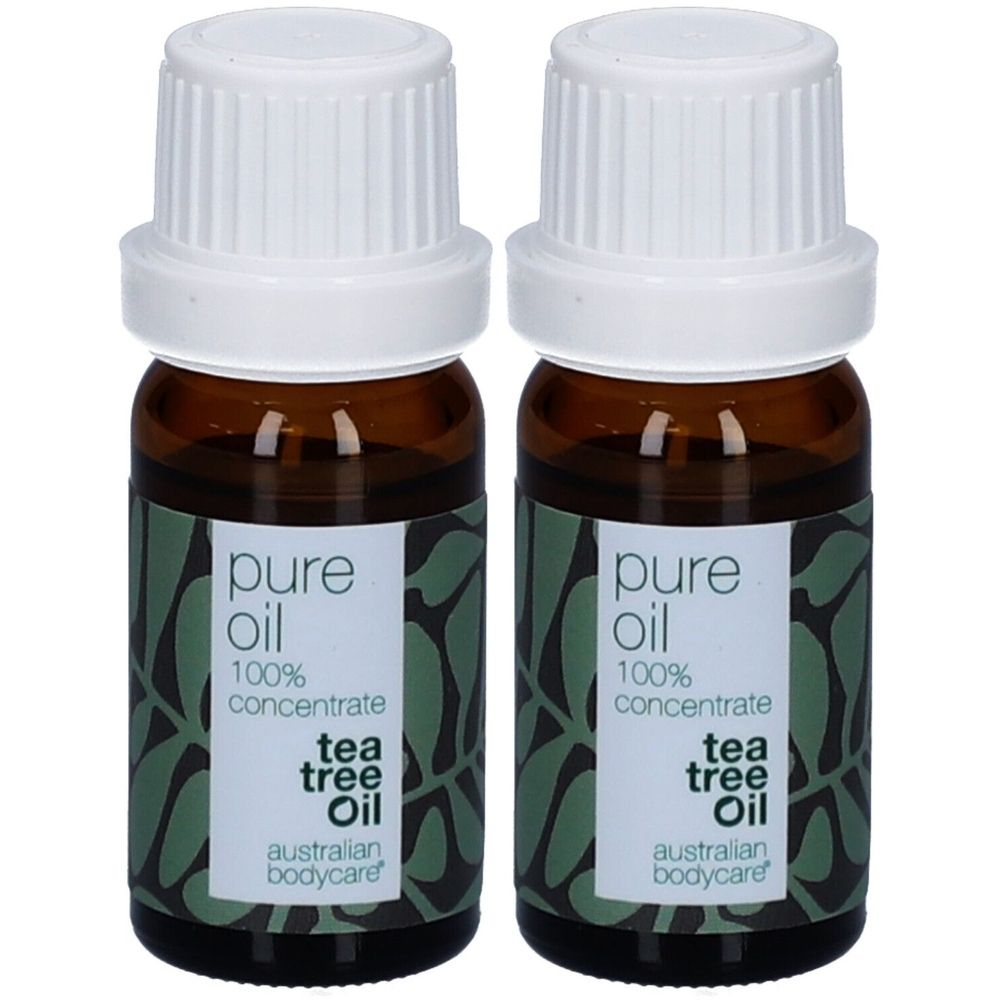 Twee flessen tea tree olie. Bruine glazen flessen met witte doppen en etiketten. Opschrift: pure oil, 100% concentrate, tea tree oil, Australian Bodycare.
