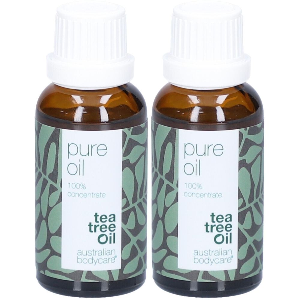 Twee flessen tea tree olie. Bruine glazen flessen met witte doppen. Etiket met tekst 'pure oil' en 'tea tree oil'.